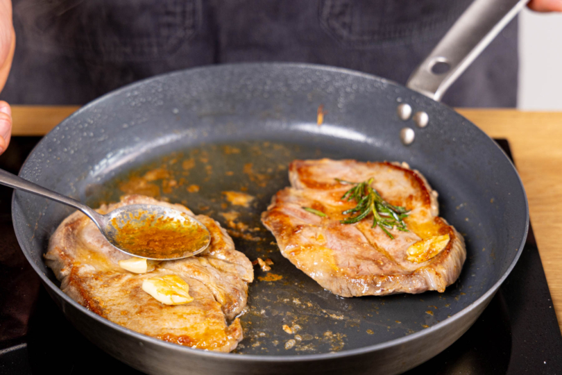 Schweinesteaks mit Fett übergießen