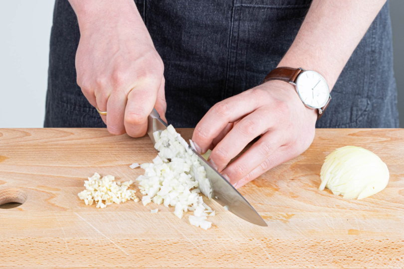 Zwiebel und Knoblauch schälen und in feine Würfel schneiden